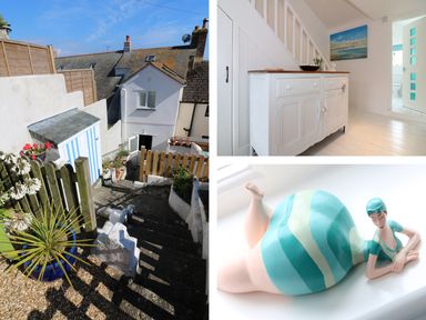 An outdoor stone staircase leading to a white house with a small garden shed a white sideboard with a wooden top under stairs and a ceramic figurine of a woman in a blue striped swimsuit at Ner Sea in Marazion