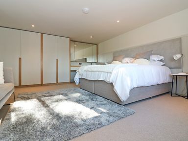 A bedroom with a bed with pillows and a rug on the floor at Mill House Boskensoe Barns Mawnan Smith near Falmouth
