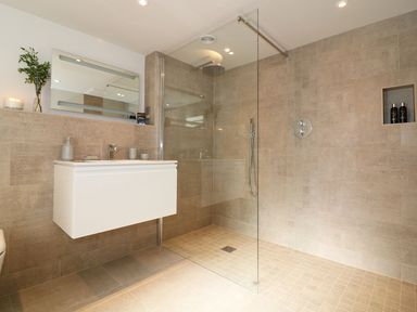 A bathroom with a floating vanity unit a large mirror and a walk in shower with glass partition at Mill House Boskensoe Barns Mawnan Smith near Falmouth
