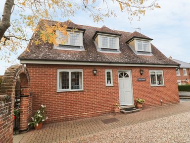A brick house with three dormer windows and a white door at The Lodge off High Street in Hadleigh
