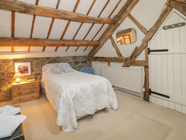A bedroom with a bed bedside table and a radiator at Lower Dolgenau The Cottage in Llawryglyn near Llanidloes