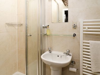 A bathroom with a sink shower and towel rack at Lower Dolgenau The Cottage in Llawryglyn near Llanidloes