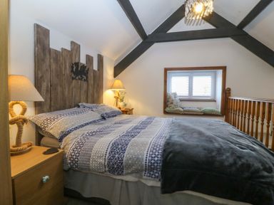 A bedroom with a bed and nightstand at The Cottage in Marian-Glas