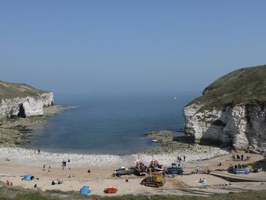 A beach with cliffs and boats on the sand at Lilly May Cottage in Flamborough