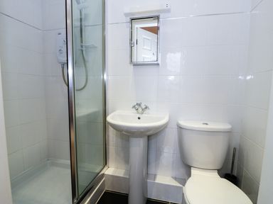 A bathroom with a shower cubicle sink toilet and mirror at Apartment 3 Marian Y Mor Pwllheli