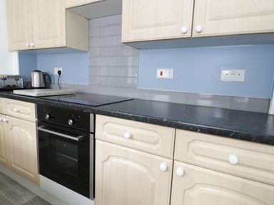 A kitchen countertop with a toaster kettle oven and light wood cabinets at No 9 in Watchet