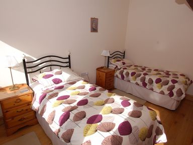 A bedroom with two single beds and wooden nightstands with lamps at The Milking Parlour in Wookey