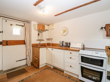 A kitchen with white cabinets wooden countertops a double oven a kettle toaster and bread box at The Granary in Edington near Street and Glastonbury