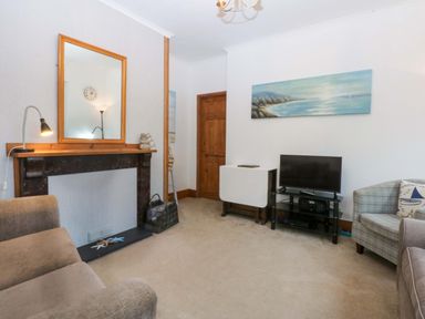 A living room with a television and seating area at 2 Argoed Llanbedrog