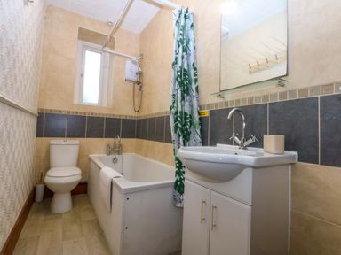 A bathroom with a shower, sink and toilet at 2 Argoed Llanbedrog