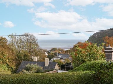 A view of the sea and surrounding houses at 2 Argoed Llanbedrog