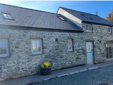 A house exterior with stone walls and a pathway at Storws Tanrallt Llanfachraeth