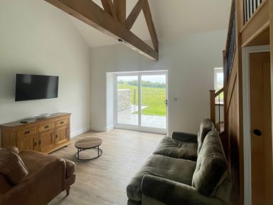 A living room with a sofa and television at Storws Tanrallt in Llanfachraeth
