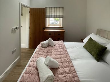 A bedroom with a bed and wooden furniture at Storws Tanrallt Llanfachraeth