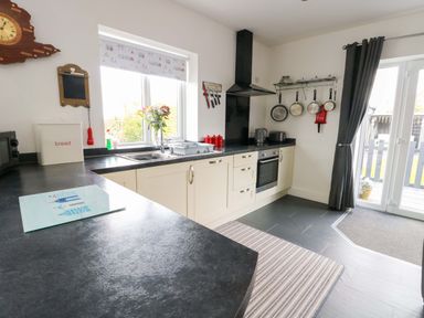 A kitchen with a sink and cabinets at Hafod Wen in Pentraeth