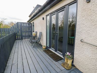 An outdoor space with seating and flower pots at Hafod Wen in Pentraeth