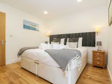 A bedroom with a double bed bedside tables and wooden floor at Beech in Truro