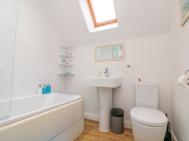 A bathroom with a bathtub sink toilet and skylight at Dotty's Sunshine Cottage in The Bay near Filey