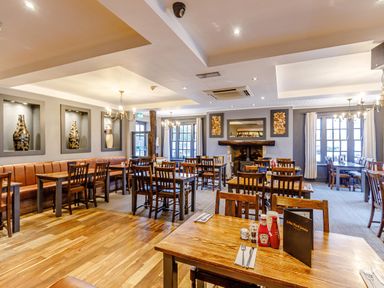 A dining room with wooden tables and chairs and decorative vases on the wall at Dotty's Sunshine Cottage in The Bay near Filey