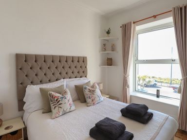 A bedroom with a bed and decorative pillows at Wavecrest in Pwllheli