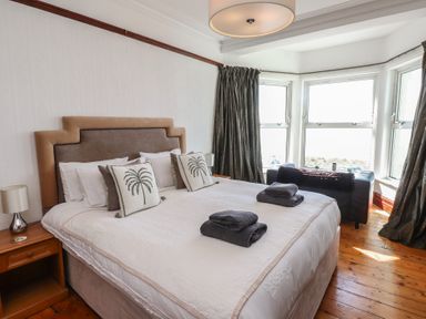A bedroom with a bed and bedside table at Wavecrest in Pwllheli