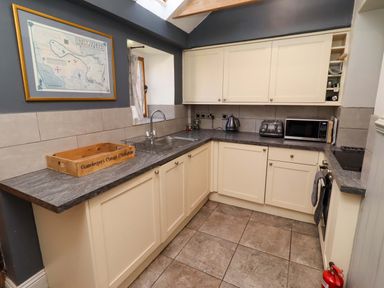 A kitchen with a sink and appliances at Gamekeepers Cottage Chillingham near Chatton