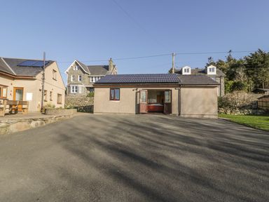 A building with solar panels on the roof and a driveway at Awel Y Llan in Llanfair