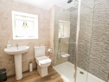 A bathroom with a pedestal sink toilet and glass enclosed shower at Ffrwdd Galed Uchaf in Tregarth