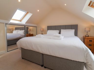 A bedroom with a double bed and bedside tables at The Old Byres in Washford near Watchet
