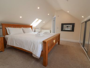 A bedroom with a bed and a mirror at The Old Byres in Washford near Watchet