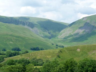 A landscape with green hills and valleys with trees at Knott Lodge in Sedbergh