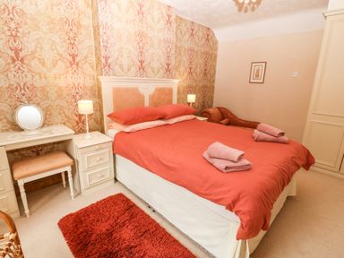 A bedroom with a double bed and bedside tables with lamps at Dinas Farmhouse Annex in Caernarfon