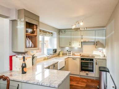 A kitchen with granite countertops cabinets oven sink and champagne bottle at South Lodge in Hazelbury Bryan