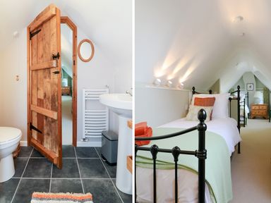 A bathroom with a wooden door next to a bedroom with black metal beds and orange and green bedding at South Lodge in Hazelbury Bryan
