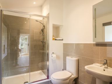 A bathroom with a glass enclosed shower, toilet, and sink at Zeal Cottage in Crediton