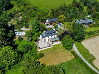 An aerial view of a house surrounded by trees fields and a driveway at Oakwood House Rhayader
