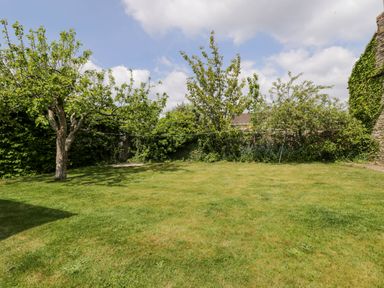A garden with grass lawn trees and a clothesline at The Barn at Daubeneys in Colerne