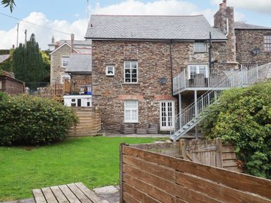 A stone house with garden and decking area at Tower House in Boscastle