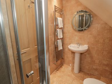 A bathroom with a sink mirror and towel rack at St Dolmen in Embleton