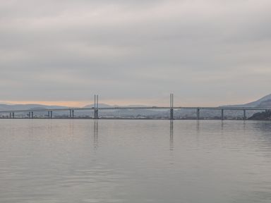 A long bridge over calm water with hills in the background at Moorhen Lodge in North Kessock