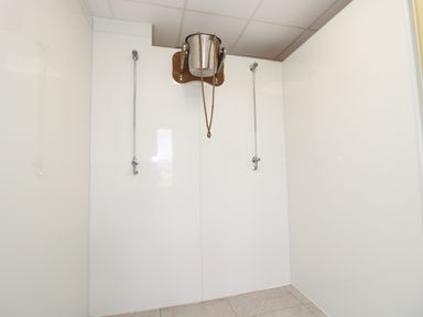 A room with two metal pipes and a wall-mounted metal bucket with ropes at Mill View in Embleton