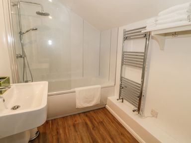 A bathroom with a sink bathtub shower and towel rack at 1 Dunkirk Cottages Humshaugh near Hexham