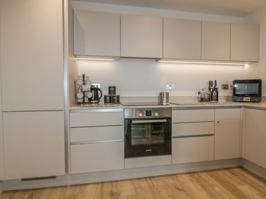 A kitchen with an oven microwave kettle and cabinets at Chapel Rock View The Dunes Perranporth