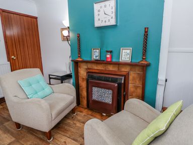 A living room with a fireplace and chairs at Blaenywawr near Lampeter