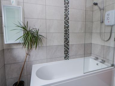 A bathroom with a bathtub and showerhead at Blaenywawr near Lampeter