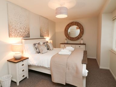 A bedroom with a double bed and bedside tables with lamps Kingfisher Cottage Ilfracombe