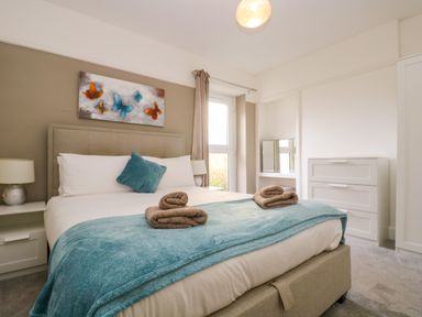 A bedroom with a bed and towels on a blue blanket at Pound Rocks in Tintagel