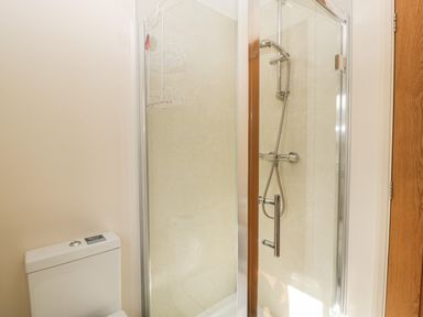 A bathroom with a glass shower enclosure and a white toilet at Timber Barn in Eardisland