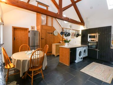 A kitchen with a table and chairs at Beudy Mawr Y Felinheli