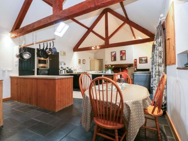 A kitchen with a dining table and chairs at Beudy Mawr Y Felinheli